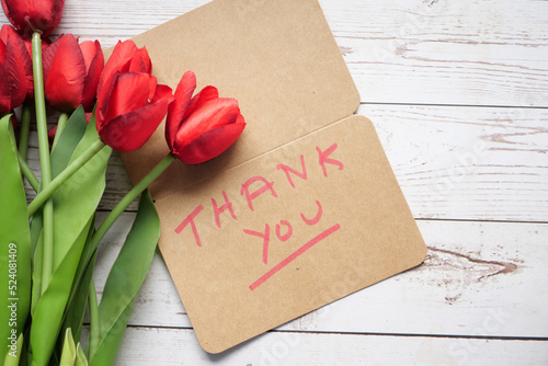 thank you message, envelope o and red tulip flower on ted background photo