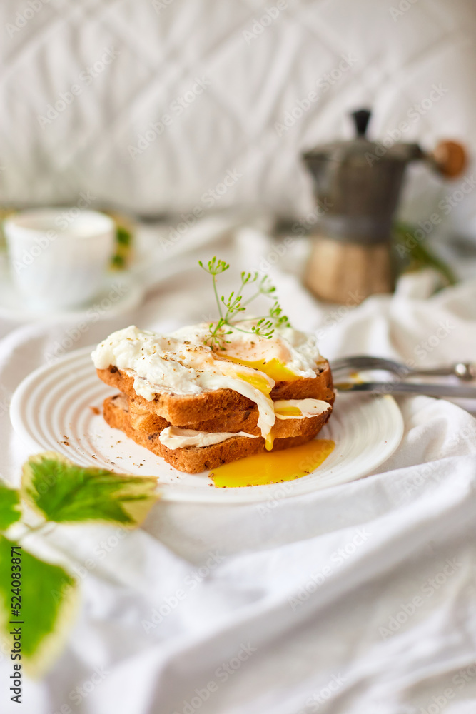 Breakfast on white bed sheets, good morning, toast with poached eggs, coffee, flowers, Hotel room early morning, honeymoon Breakfast on white bed sheets, good morning, toast with poached eggs, coffee, flowers, Hotel room early morning, honeymoon