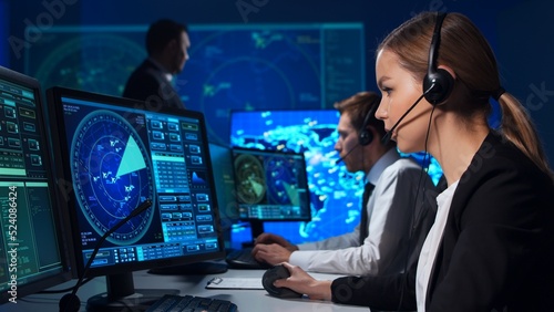 Workplace of the air traffic controllers in the control tower. Team of professional aircraft control officers works using radar, computer navigation and digital maps. Aviation concept.