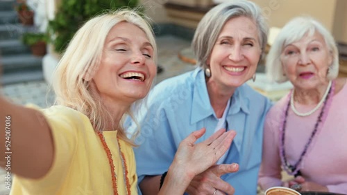 Happy group of senior women having a cappuccino in a cafe and spending good quality time together. Concept about lifestyle and seniority photo