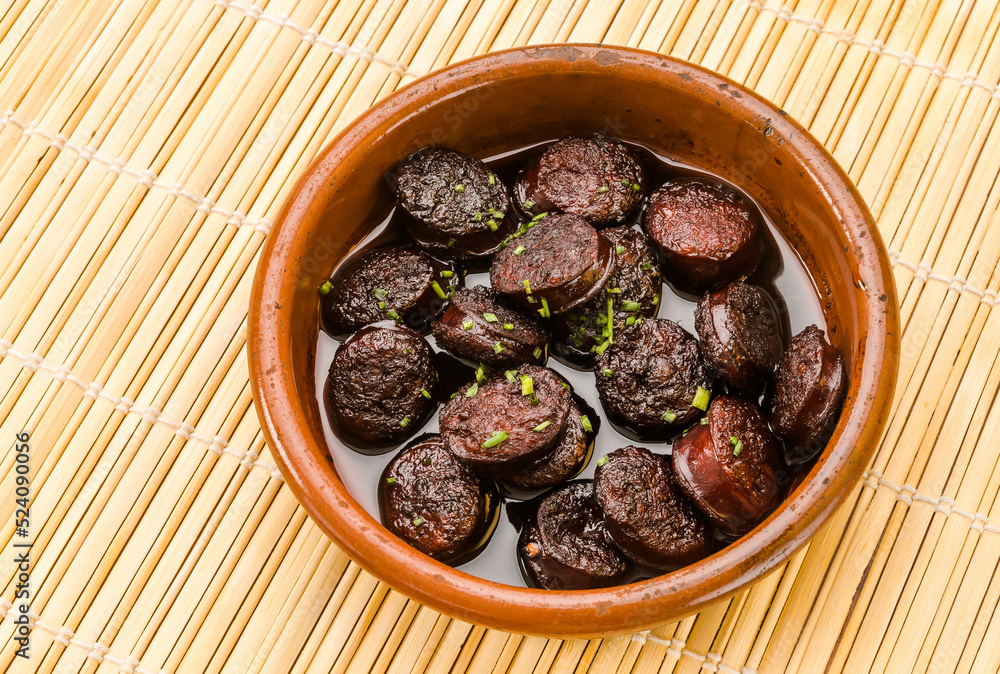 Chorizo in wine, tapas and typical Spanish food in a clay pot. Chorizo in wine, tapas and typical Spanish food in a clay pot.