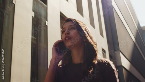 Young woman walking on street and walking by mobile phone