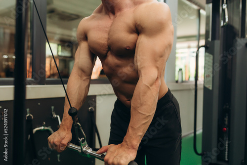 Close-up of man doing exercises on muscles of triceps in simulator. Muscles on arms, ligaments. Concept workout, bodybuilder in gym