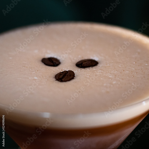Martini glass with foam and three coffee beans