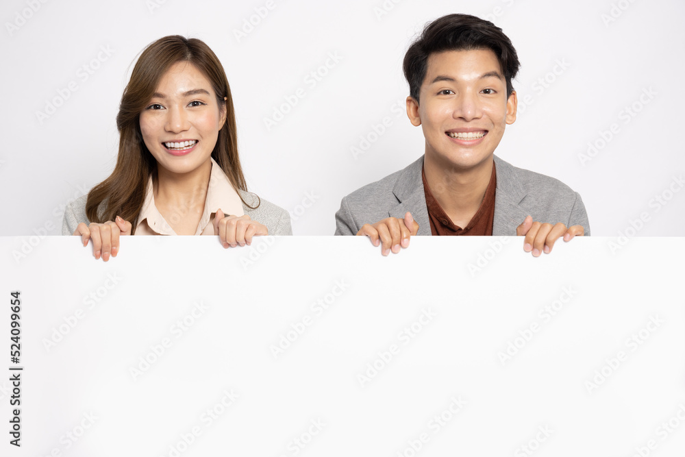Asian businessman and businesswoman is standing behind the white blank banner or empty copy space advertisement board isolated on white background Asian businessman and businesswoman is standing behind the white blank banner or empty copy space advertisement board isolated on white background