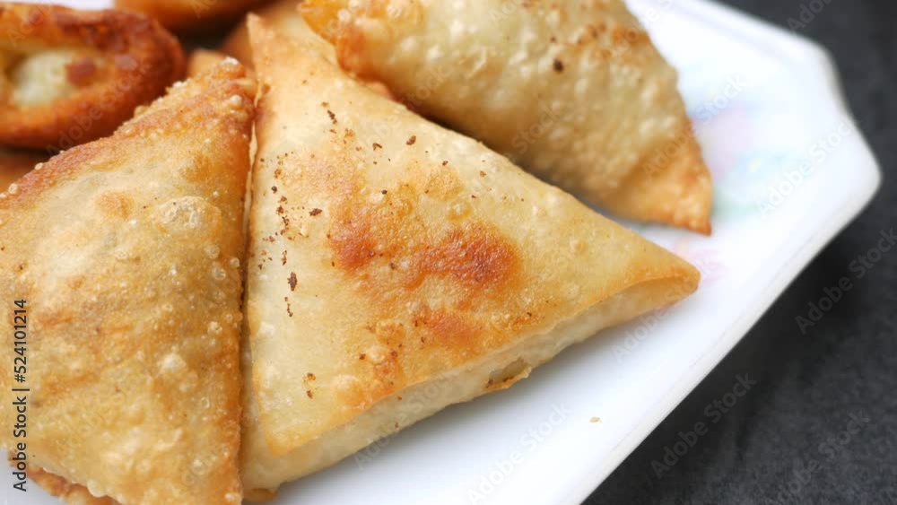 top view of Indian samosa and tomato on a plate top view of Indian samosa and tomato on a plate