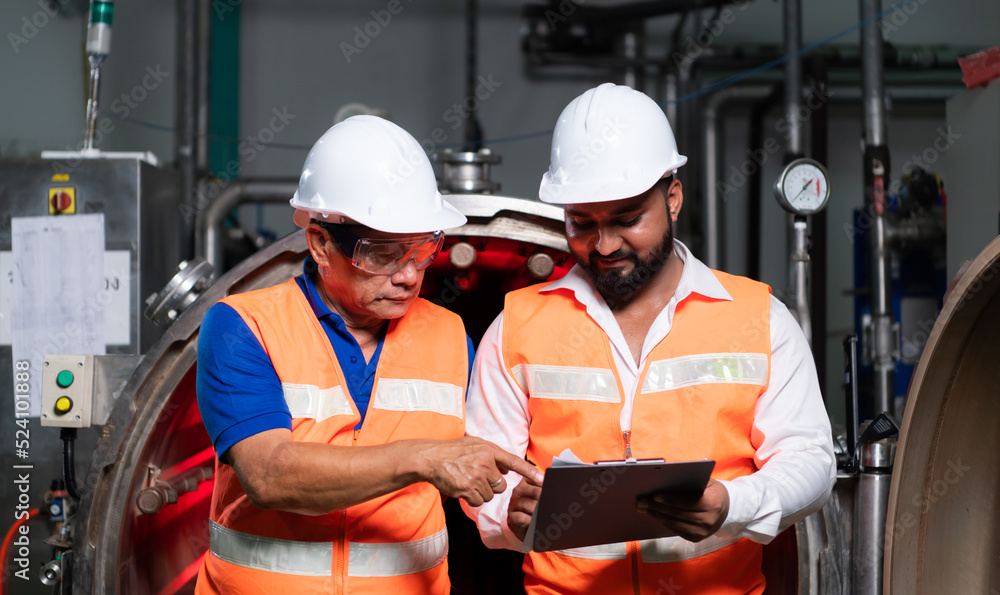 Chief engineer of a mechanical plant Inspecting and explaining the maintenance of the machine to the mechanic Chief engineer of a mechanical plant Inspecting and explaining the maintenance of the machine to the mechanic