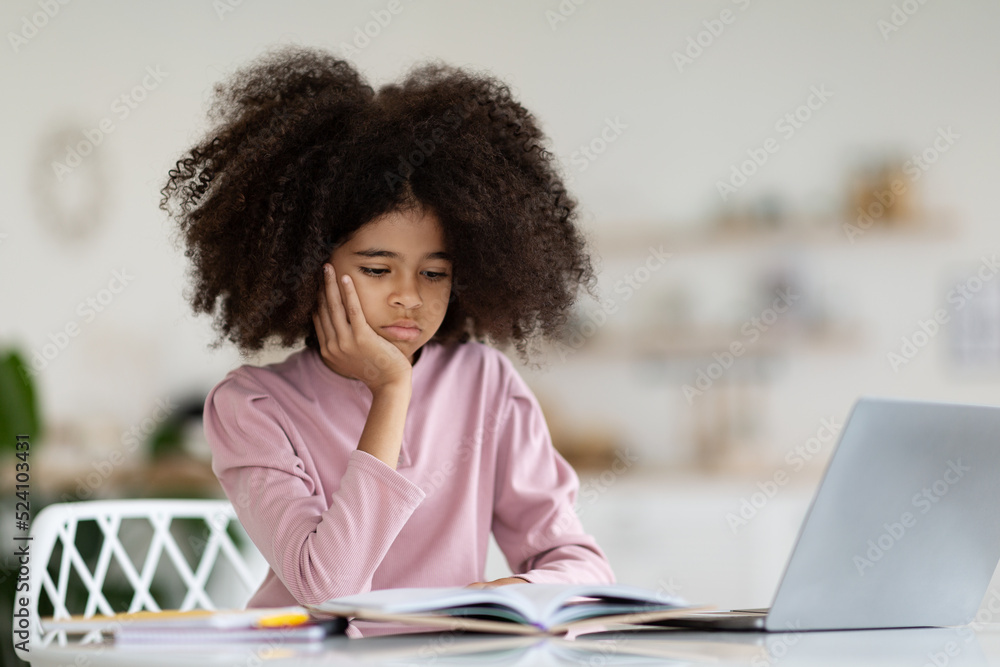 Bored african american kid suffering while doing homework Bored african american kid suffering while doing homework