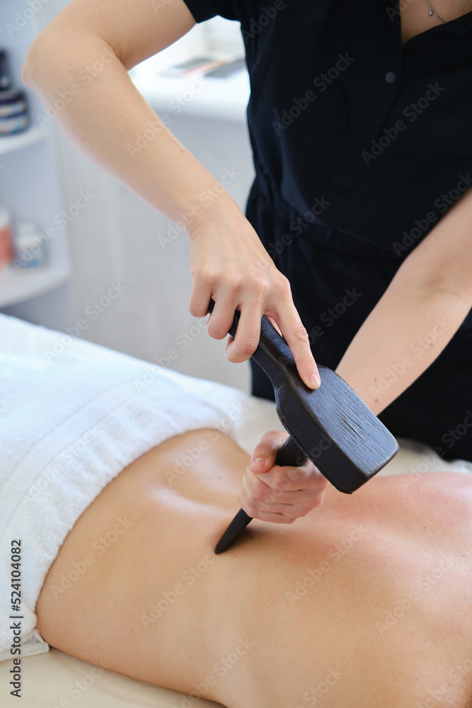 Close-up of a professional massage therapist doing a back massage. Relaxation, body care, beauty, healthy lifestyle, tranquility, anti-stress help. Spa treatments for the body