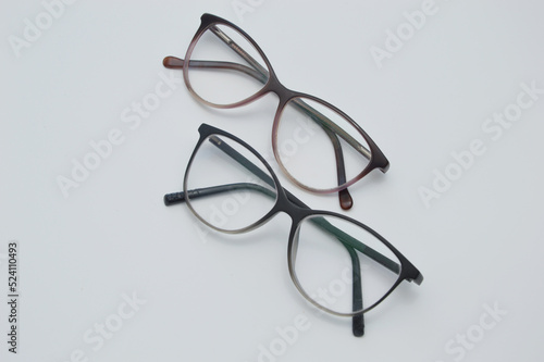 Glasses for vision correction in a dark frame lie on a light background.