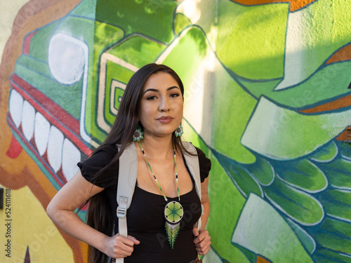 Native girl student looks into camera for portrait in front of school
