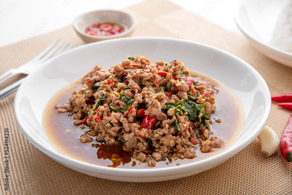 Rice topped with stir-fried pork and basil. Stir fried basil. on wooden table background. top ten thaifood menu Rice topped with stir-fried pork and basil. Stir fried basil. on wooden table background. top ten thaifood menu