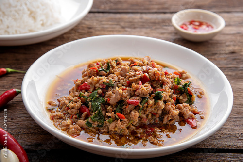 Rice topped with stir-fried pork and basil. Stir fried basil. on wooden table background. top ten thaifood menu © Hyper Bee