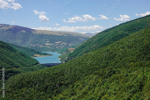 Panorama of the Fiastra Lake on the Sibillini Mountains in Marche. The lake is in the middle of a green forest. Italy © Marco
