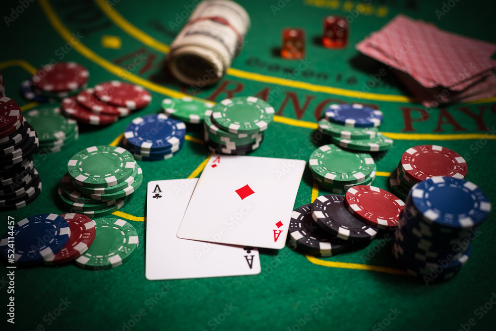 Fototapeta premium A closeup cards and different chips spread on a poker table