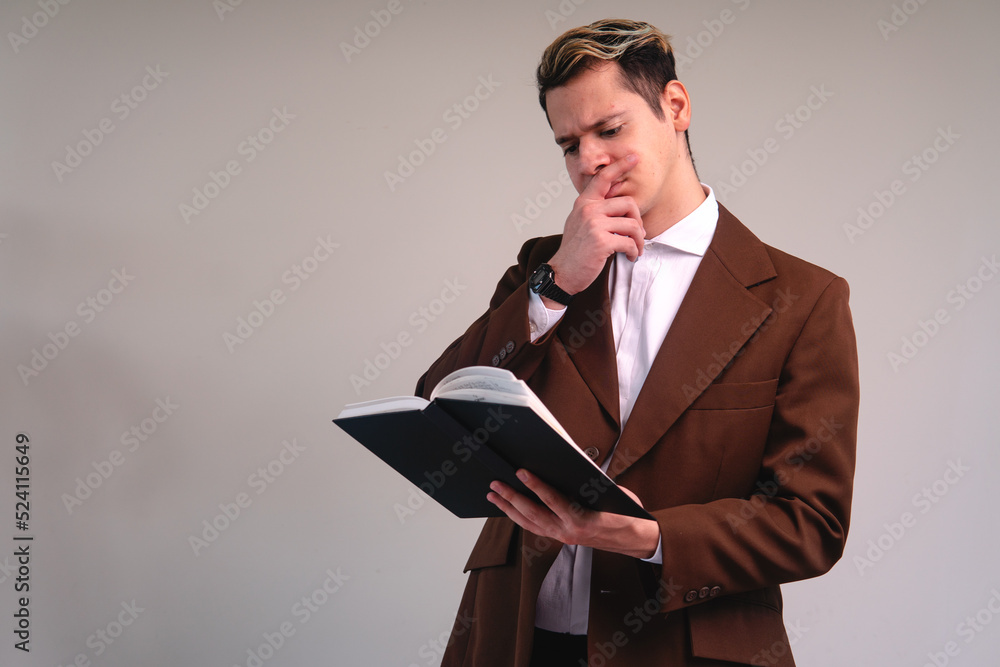 Business man reading on a white background. Caucasian man dressed in brown suit and white shirt. Lawyer reading worried. Business man reading on a white background. Caucasian man dressed in brown suit and white shirt. Lawyer reading worried.