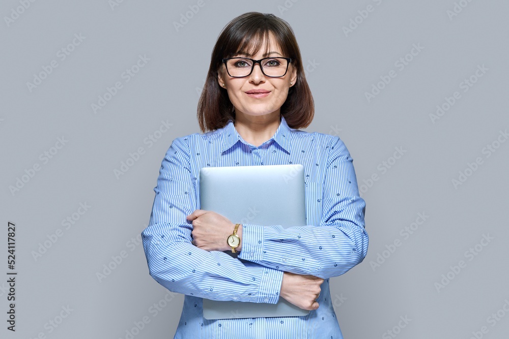 Smiling business woman with laptop on gray background Smiling business woman with laptop on gray background