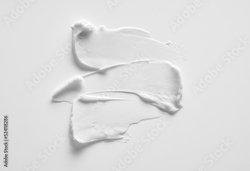 White smear of cosmetic cream or acrylic paint isolated on white background.