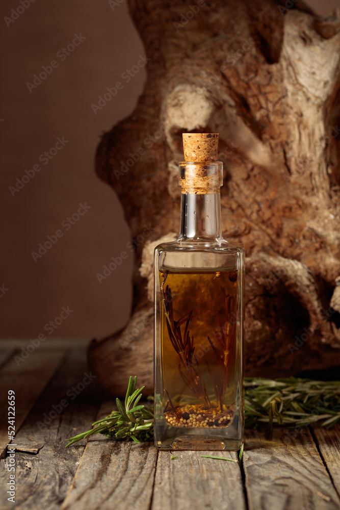 Olive oil with rosemary and spices on an old wooden table. Olive oil with rosemary and spices on an old wooden table.