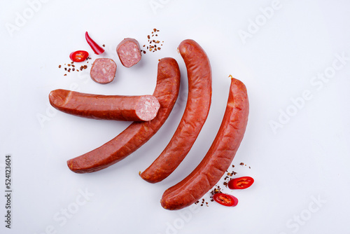 Traditionelle rohe bayrische scharfe Bratwurst mit Chili angeboten als Draufsicht auf weißem  Board mit Textfreiraum  photo