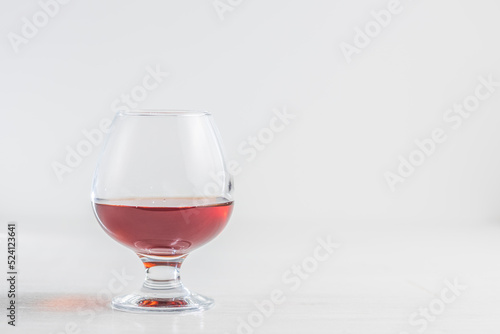 A glass of cognac or brandy on a light background. Empty space for the copy space on the right
