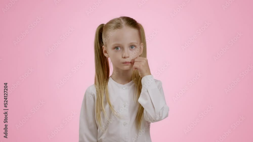 Kids and privacy. Studio portrait of mysterious little girl with ponytails zipping her lips and showing hush gesture Kids and privacy. Studio portrait of mysterious little girl with ponytails zipping her lips and showing hush gesture