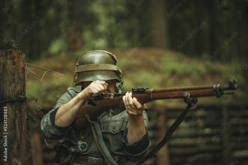Fototapeta premium A soldier of the Finnish army during World War II, shoots a rifle in the forest.
