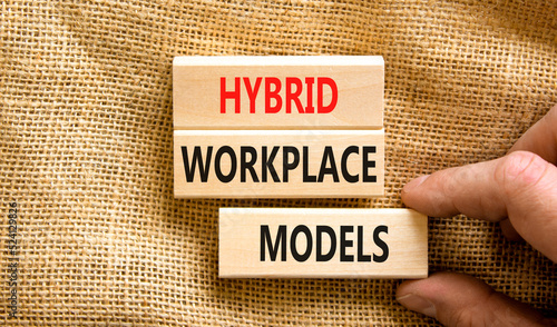 Hybrid workplace models symbol. Concept words Hybrid workplace models on wooden blocks. Businessman hand. Beautiful canvas background. Business hybrid workplace models quote concept. Copy space