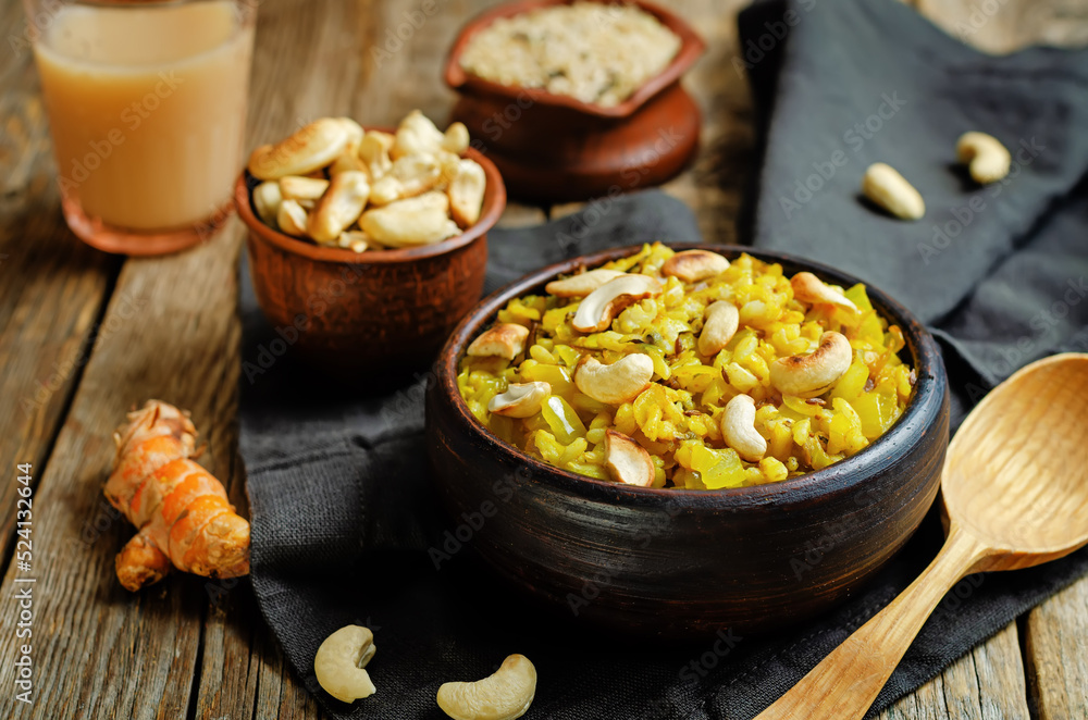 Curry rice with fried onion and roasted cashews on a wood background Curry rice with fried onion and roasted cashews on a wood background