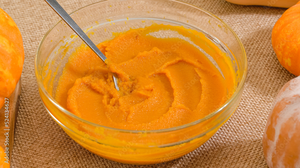 Fresh pumpkin puree in a glass bowl close up on rustic background. Making pumpkin puree from scrach Fresh pumpkin puree in a glass bowl close up on rustic background. Making pumpkin puree from scrach