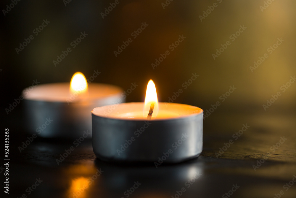 Selective focus. Dark background with burning candles and golden bokeh for a special occasion Selective focus. Dark background with burning candles and golden bokeh for a special occasion