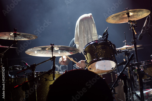 Drummer with a towel on his head during rock concert