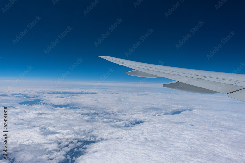 Wing of a flying plane over clouds on the blue sky. Wing of a flying plane over clouds on the blue sky.