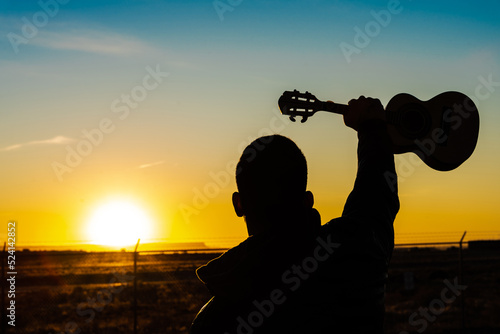 Musician and a little guitar called cavaco during the sunrise in Arizona photo