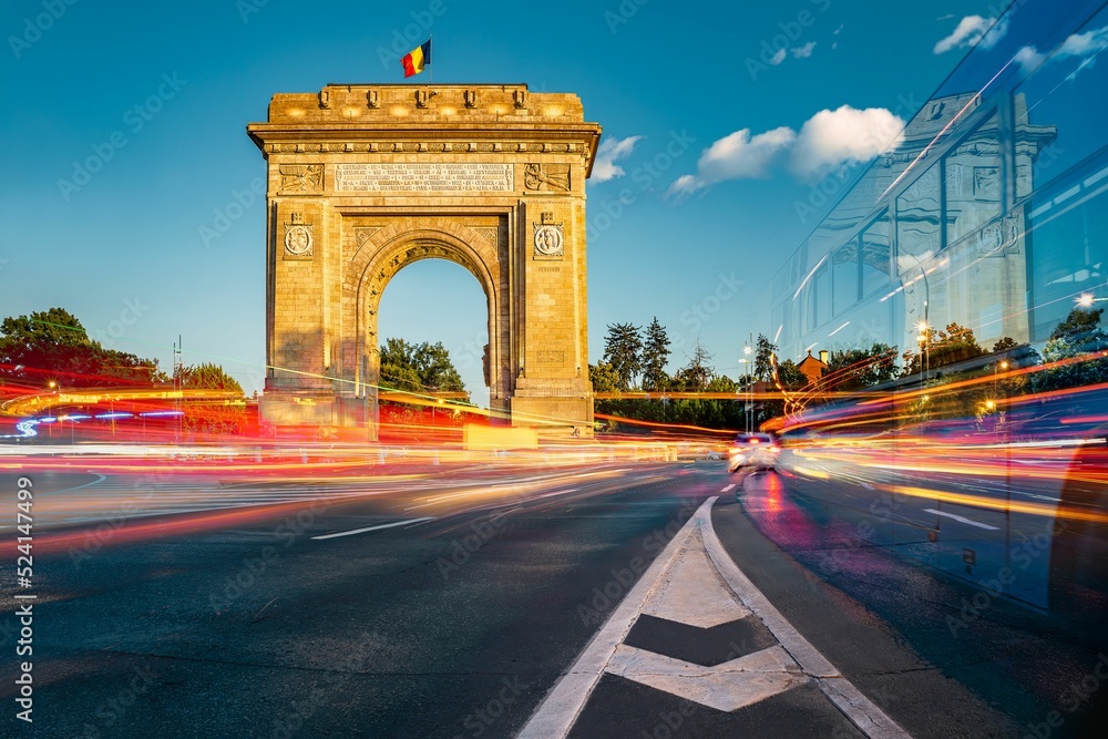 Obraz na płótnie Triumphal arch, historical landmark in Bucharest, Romania with long exposure, car light trails w salonie