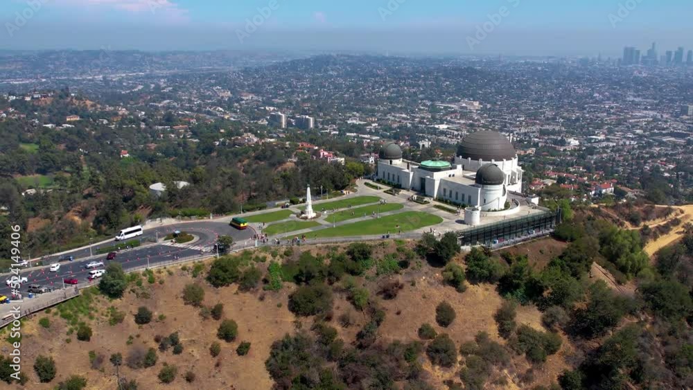 A circular flight over the Griffith Observatory in Los Angeles, California. the silhouette of Los Angeles is visible in the distance. general plan A circular flight over the Griffith Observatory in Los Angeles, California. the silhouette of Los Angeles is visible in the distance. general plan