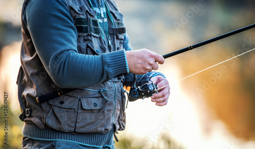 Fisherman angling on the river, close up photo. Sport and recreation concept