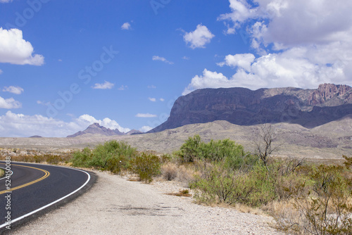 the road to the mountain range in desert  high cliffs with clouds