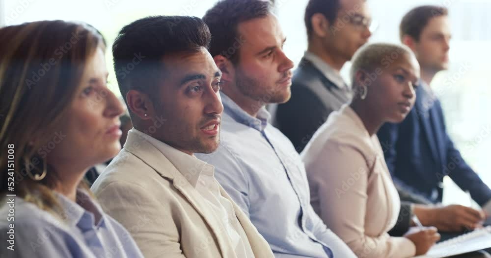 Indian businessman asking a question during a conference at a modern office. Group of coworkers attending a corporate tradeshow. Team of diverse people at a business seminar or presentation Indian businessman asking a question during a conference at a modern office. Group of coworkers attending a corporate tradeshow. Team of diverse people at a business seminar or presentation