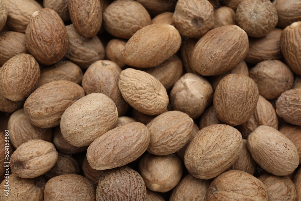 Heap of nutmeg seeds as background, closeup Heap of nutmeg seeds as background, closeup