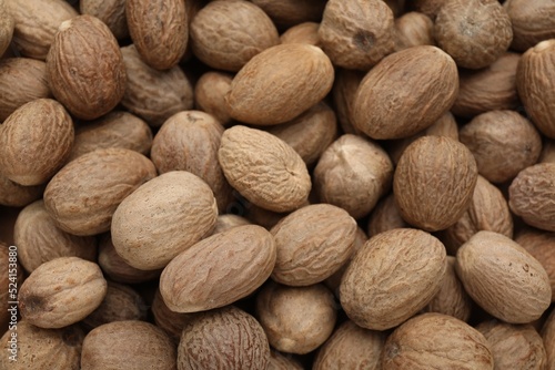 Canvas Print Heap of nutmeg seeds as background, closeup