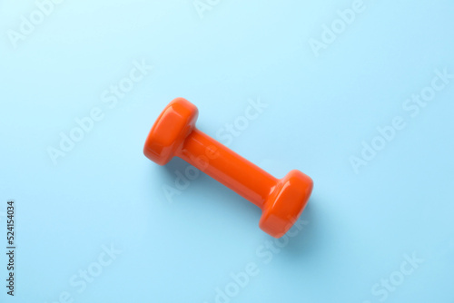 Stylish dumbbell on light blue background, top view