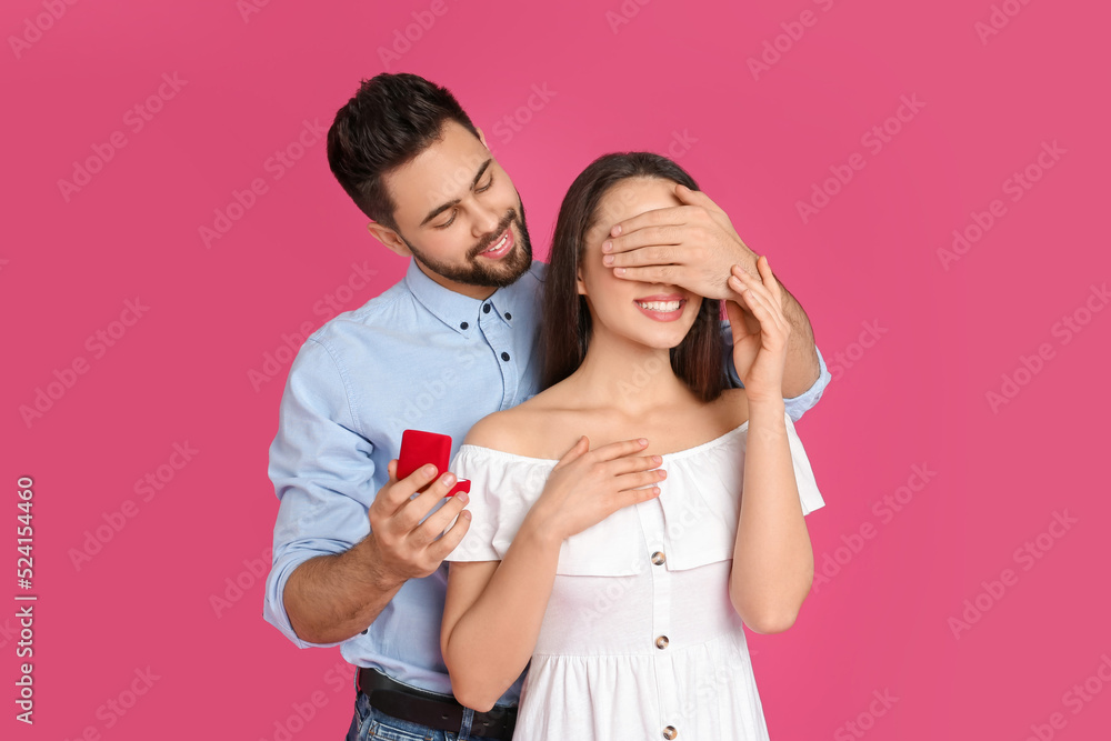 Man with engagement ring making marriage proposal to girlfriend on crimson background Man with engagement ring making marriage proposal to girlfriend on crimson background