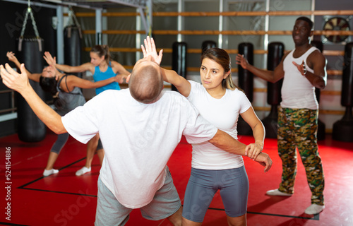 Latino girl self defense training gym learning to do painful grip