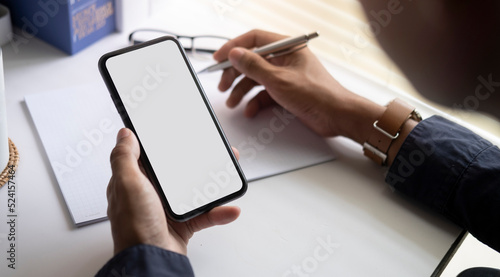 Man holding mock up smart phone. Blank screen for your text message or information content.