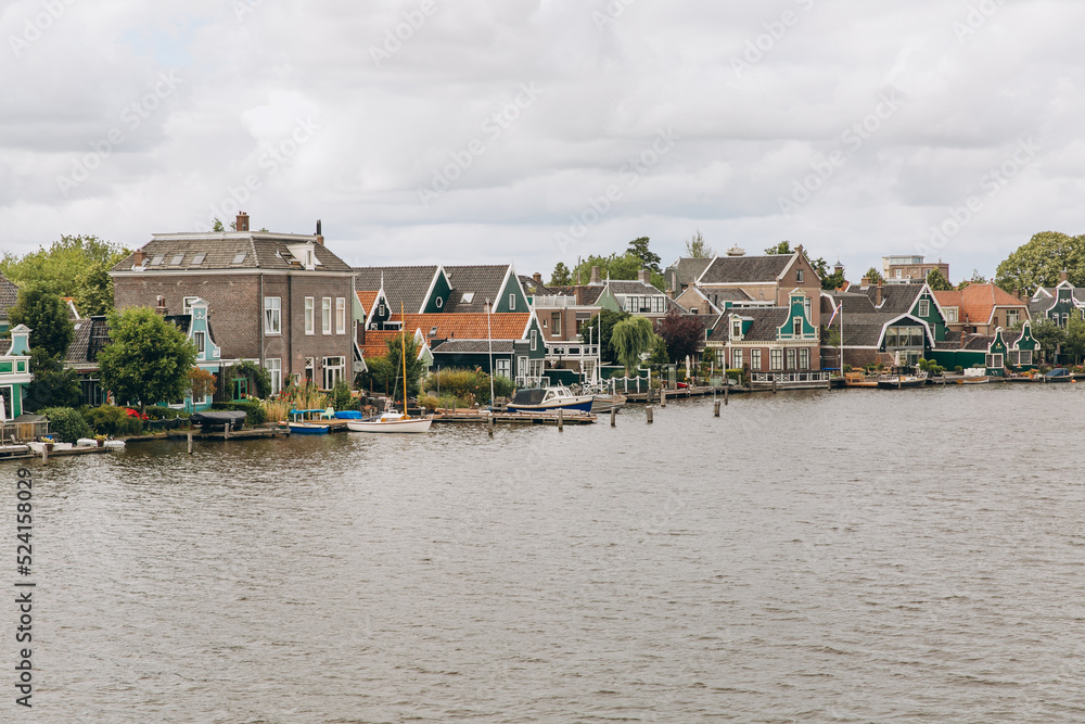 Obraz premium Traditional Dutch Houses in the Historic Village of Zaanse Schans on the Zaan River in the Netherlands