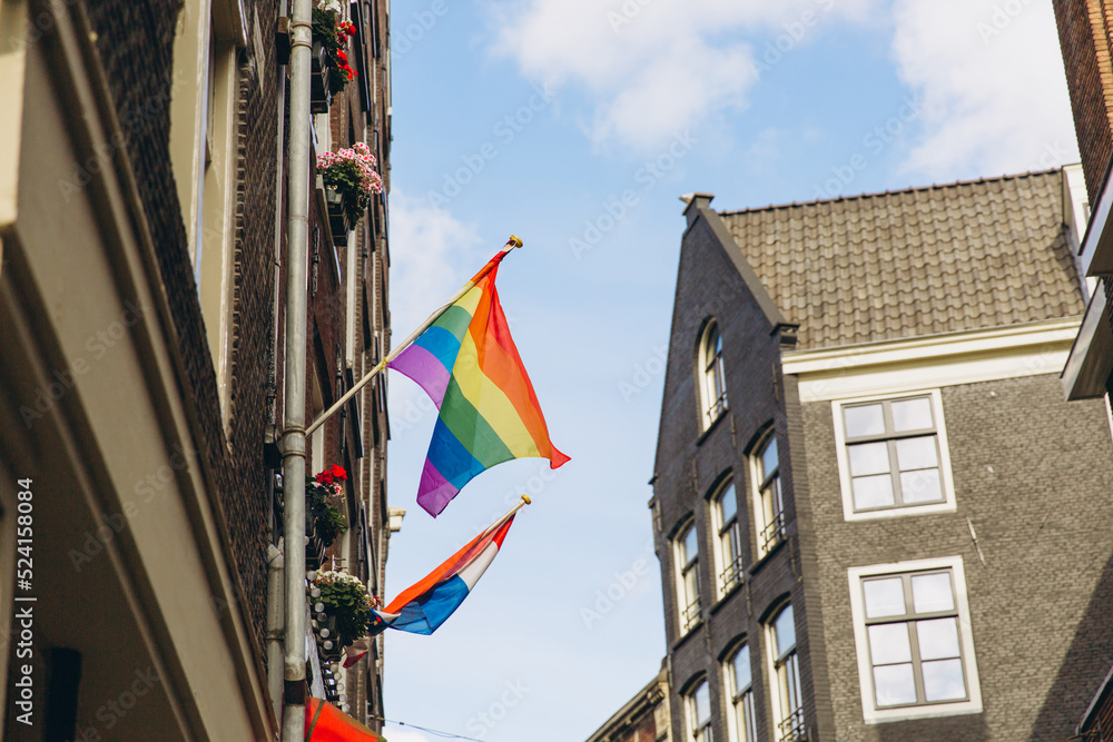 Gay flag in Amsterdam. Gay rainbow flag on a building. Rainbow flag of the LGBT community on the building on street Amsterdam.