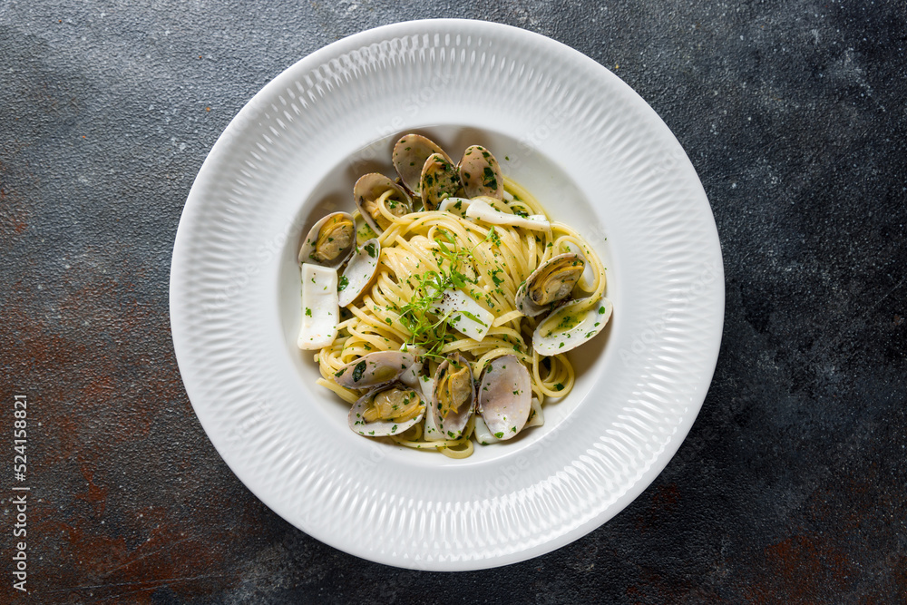 Linguini with vongole in wine sauce on white plate top view Linguini with vongole in wine sauce on white plate top view