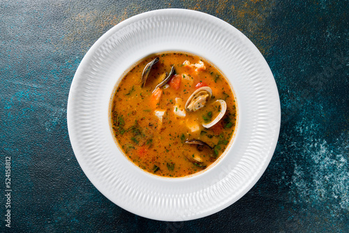 Photos Marseille fish soup with seafood on white plate on dark blue table top view