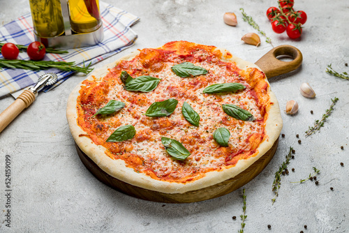 Obraz na plátně Italian pizza Margherita with cheese, tomato sauce and basil on the board on gre